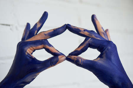 Hands in blue paint, the hands of the artist and creative person. Yoga for the hands.