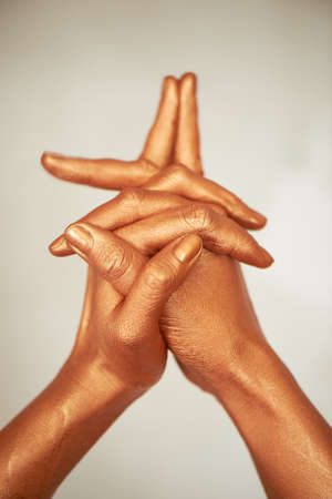 Hands in gold paint, the hands of the artist and creative person. Yoga for hands