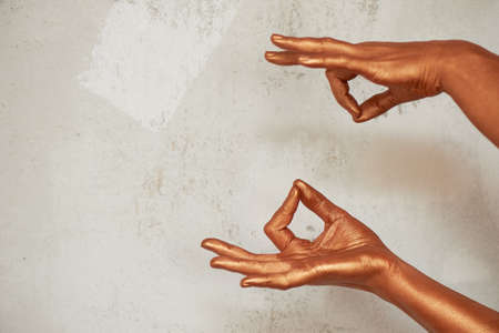 Hands in gold paint, the hands of the artist and creative person. Yoga for handsの写真素材