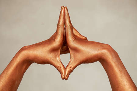 Hands in gold paint, the hands of the artist and creative person. Yoga for handsの写真素材