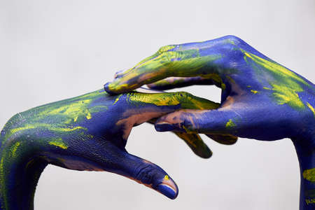 Hands in blue paint with yellow accents, hands of the artist and creative person. Yoga for handsの写真素材