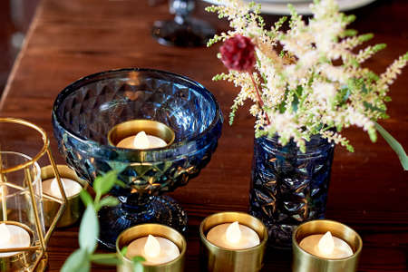 Decoration table newlyweds, blue dishes, bottles of flowers and candles. Wedding floristry.の写真素材
