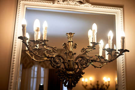 Lamp with horns against the background of a mirror in an old frame. The old interior is classic.の写真素材