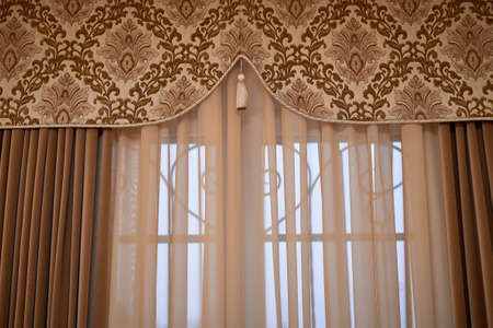 Classic curtains with tapestry insert and brush. A classic window with heavy curtains.の写真素材