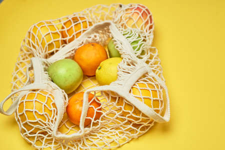 Replacing plastic bags. Taking care of the environment.Grid with fruit on colored paper,...