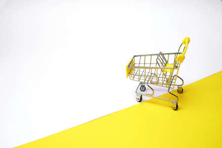 Grocery basket on wheels, minimalism. On light background. Online shopping.の写真素材