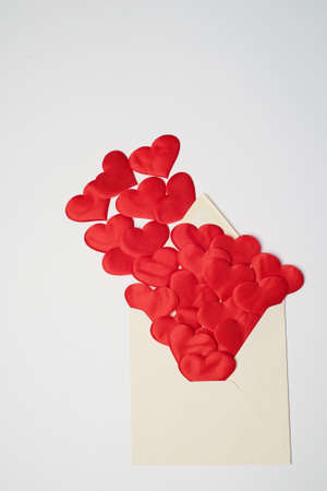 Kraft the envelope with red hearts on a white background. Congratulations on Valentines Day. Hearts fly out of the envelope.の写真素材