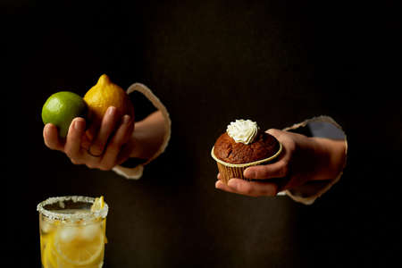 Hand in the paper hole.Dark background. Lemon, lime and lemonade. Refreshment. Collage