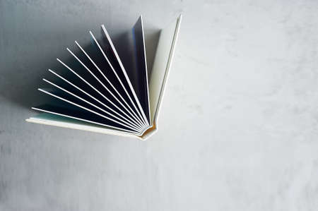 Photobook in hard leather cover on a gray concrete background. Making photos and storing them. A wedding album or book in an expensive binding.の写真素材