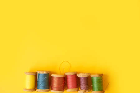 Colored coils with threads on a yellow background. Handicrafts and sewing.の写真素材