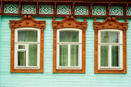 Old wooden houses with beautiful windows. Frames with tiles. An old Russian house.