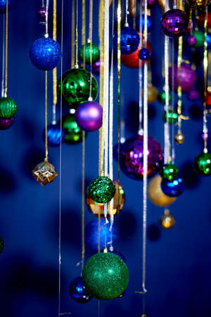 New Years garland of balls and rain against the blue wall. Bright festive colors. Celebrating the...