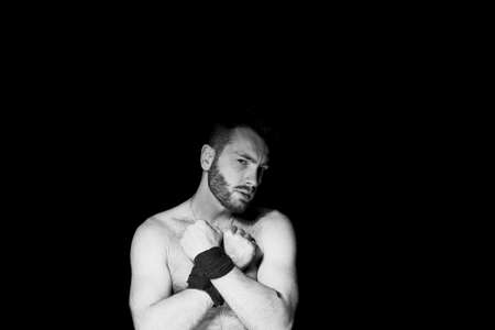 A man with his hands tied on a dark background, domination, suppression of will and lack of freedom.