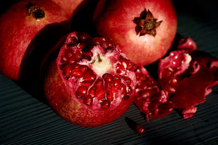 Juicy broken grenades on a dark background in bright sunlight. Vitaminsの写真素材