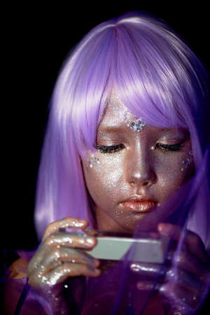 A girl with purple hair and glowing skin. An alien or a fairy with glowing skin.の写真素材