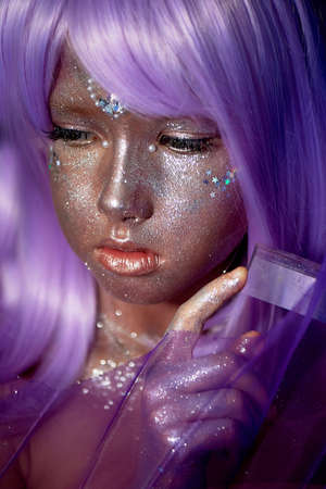 A girl with purple hair and glowing skin. An alien or a fairy with glowing skin.の写真素材