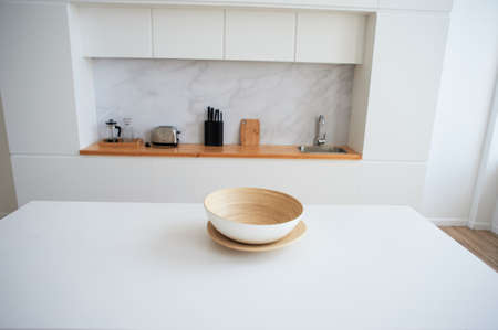 White countertop with a large light bowl for salad. Kitchen in the studio. Decor of a stylish room.の写真素材