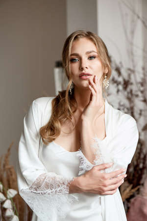 A beautiful bride is preparing for an important wedding day. The morning of the bride in the penioireの写真素材