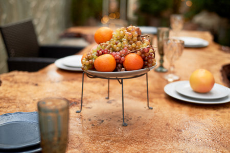 A vase of fruit on the outdoor veranda. Countertop, wet from the rain.の写真素材