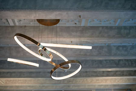 Chandelier on the concrete ceiling. Circles or rings. Luminaire design