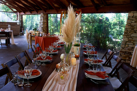 A banquet in warm orange tones under a wooden triangular roof. large terrace