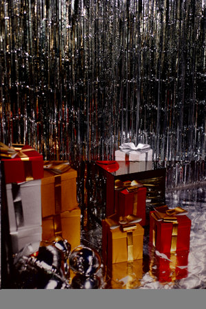 A lot of New Years gifts, silver tinsel. Red, silver, gold boxes. Festive atmosphere.