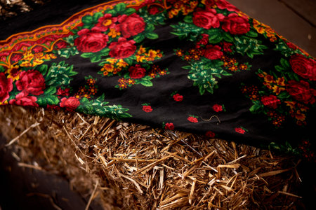 Wedding decoration in the Slavic style . Painted shawl on hay. Bright colors
