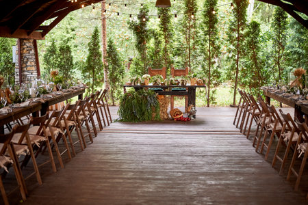 Wedding decoration in the Slavic style. In a tent in nature. Wooden tables and chairs.の写真素材