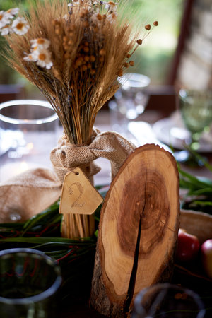 Wedding decoration in the Slavic style. Table number for guests and a bouquet of cerealsの写真素材