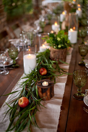 Banquet decoration in a simple rustic style with grass, greenery, simple objects and fabrics. Wedding table setting for guestsの写真素材