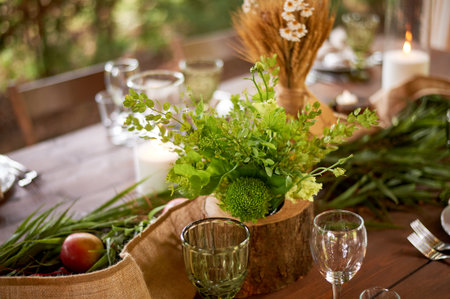 Banquet decoration in a simple rustic style with grass, greenery, simple objects and fabrics. Wedding table setting for guestsの写真素材