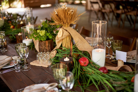 Banquet decoration in a simple rustic style with grass, greenery, simple objects and fabrics. Wedding table setting for guestsの写真素材