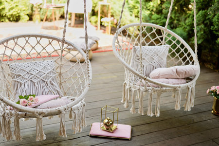 The swing is light wicker with a soft pillow in the style of macrome. Boho style, garden design.の写真素材