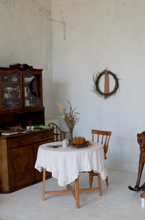 Interior in an old house. A table covered with a white tablecloth, a massive wooden wardrobe....