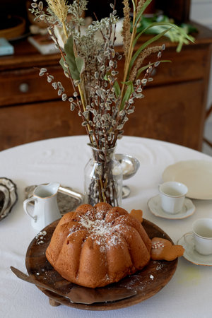 A large cake sprinkled with powder and willow sprigs. Spring comfort in the house.