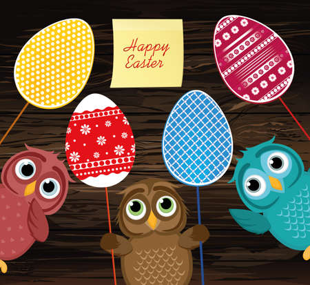Owls keep Easter decorated eggs on a stick. Multicolored.  Empty Yellow sheet of paper for notes. Sticker. Vector on wooden background. Greeting card for the holiday. Empty space for text.のイラスト素材