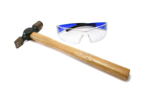 hammer and safety glasses. Hammer has an old warning sticker but it's message has been lost with use.の写真素材