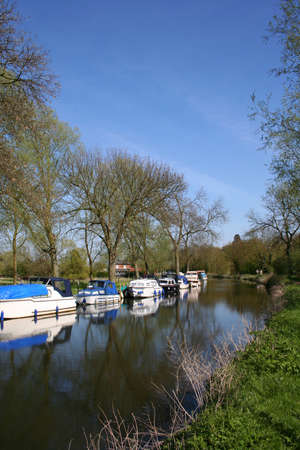 various types of boats moored along a canal bank in Springの写真素材