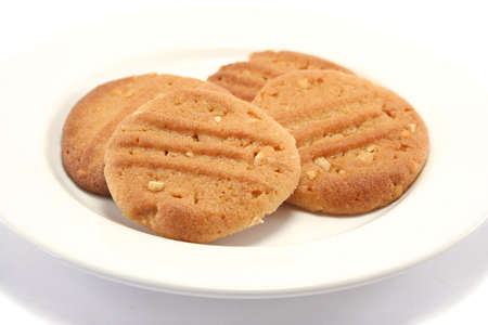 four golden peanut butter homemade cookies on a china plateの写真素材