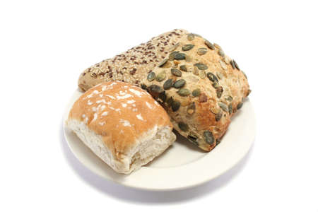 plain white roll, pumpkin seed granary roll and sesame seeded wholemeal roll on a plateの写真素材