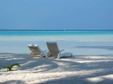 two sunloungers on a Maldivian beachの写真素材