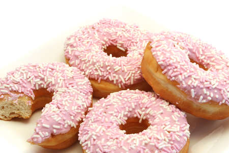 Four Iced Donuts Closeup with a bite taken from oneの写真素材