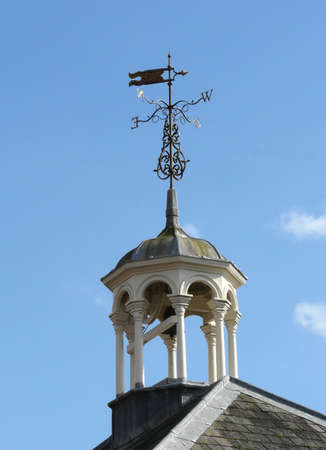 Ornate bell tower and weather vane against lovely Spring blue skyの写真素材