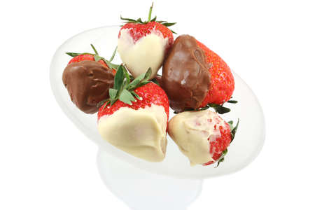Milk and white chocolate dipped strawberries in a frosted glass bowlの写真素材