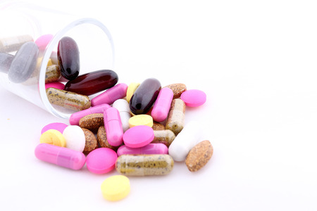 Pills of many shapes and colors grouped together