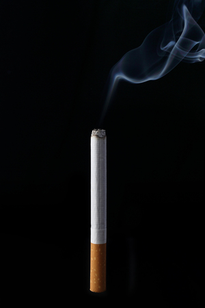 Realistic burning cigarette on black backgroundの写真素材