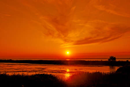 sundown sun in calm sea by summerの写真素材
