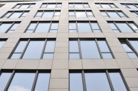 wall of the building with set of the windows with reflection skyの写真素材