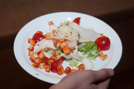 hand waiter bring plate with fried meat and lettuce leavesの写真素材