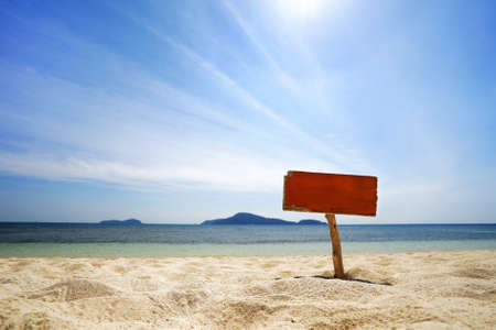 Wooden signboard with sand on the shore of a tropical island.の写真素材